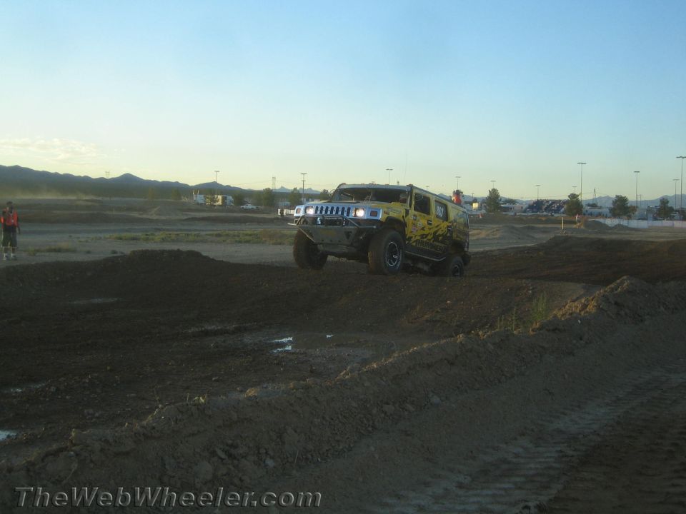 Yellow Hummer H2 off-road on a dirt track at dusk