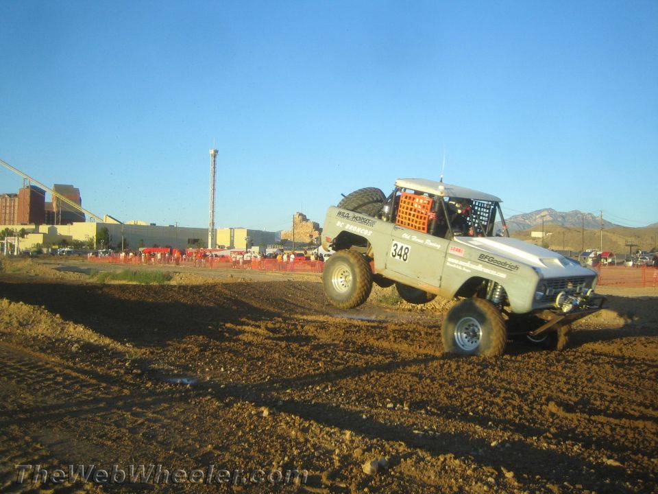 Light number 348 off-road race truck cornering on dirt with spare tire