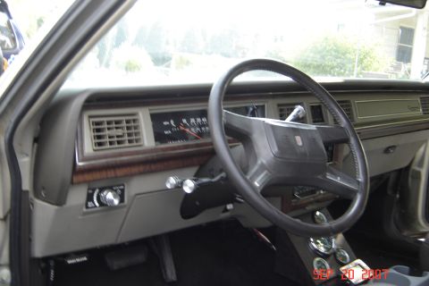 1989 Ford Crown Victoria LTD - The dashboard of a car, the steering wheel and instrument panel, is shown from the driver's perspective.