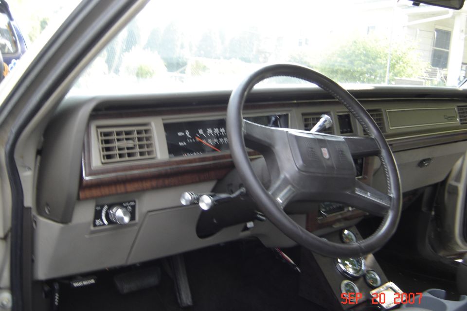 Interior shot of a car's dashboard, showing the steering wheel, instrument cluster, and center console