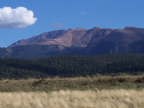 1972 Ford Ranchero - Mountain landscape with a forest and a single cloud in the sky.