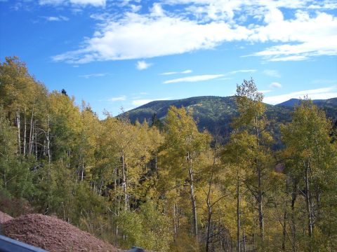 1972 Ford Ranchero - Autumn foliage blankets a mountainside under a bright blue sky with scattered clouds.