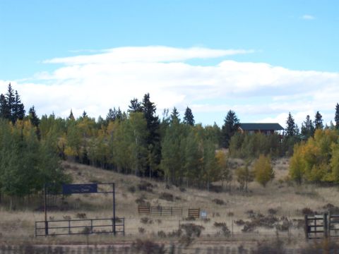 1972 Ford Ranchero - A scenic view of a house among trees on a hillside, with a gate and fence in the foreground.