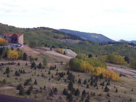 1972 Ford Ranchero - A view of a building and vehicles on a hillside during autumn.