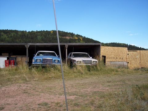 1972 Ford Ranchero - Two cars, a 1977 Ford LTD II and another vehicle, are parked under a carport.