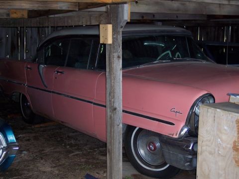 1972 Ford Ranchero - This pink sedan, possibly a 1955 Capri, is parked inside a wooden structure.