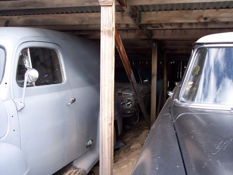 1972 Ford Ranchero - Two vintage vehicles are stored under a wooden roof structure.