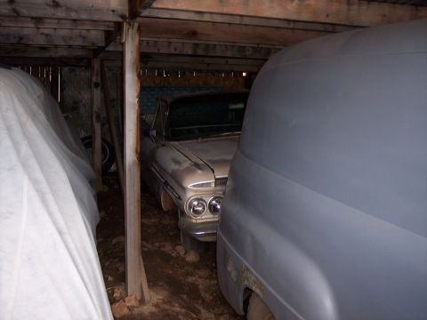 1972 Ford Ranchero - A vintage sedan, possibly from the early 1960s, is stored in a rustic shed alongside another vehicle.