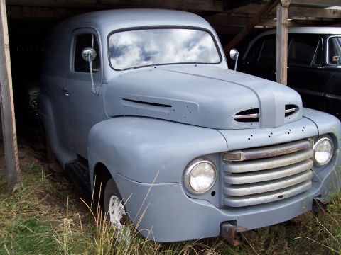 1972 Ford Ranchero - A gray panel van, likely from the late 1940s, sits in a sheltered area next to another vehicle.
