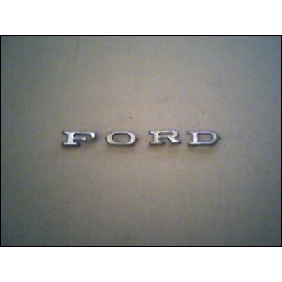 1973 Ford Ranchero - A chrome Ford emblem is visible on a neutral background.