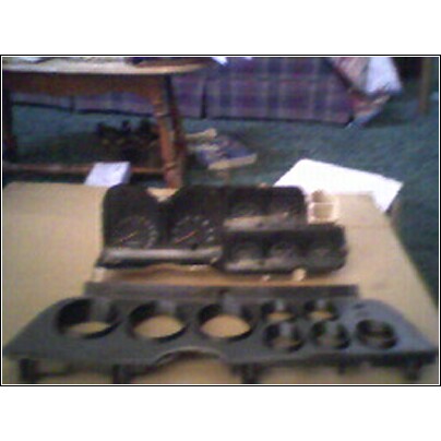 1973 Ford Ranchero - Several automotive dashboard instrument cluster components are laid out on a table.