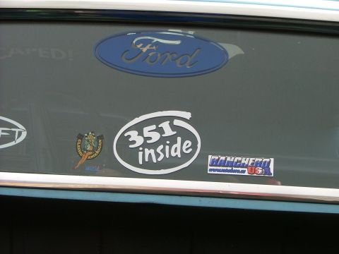 1970 Ford Ranchero - A Ford emblem and various stickers are displayed on the rear window of a vehicle.