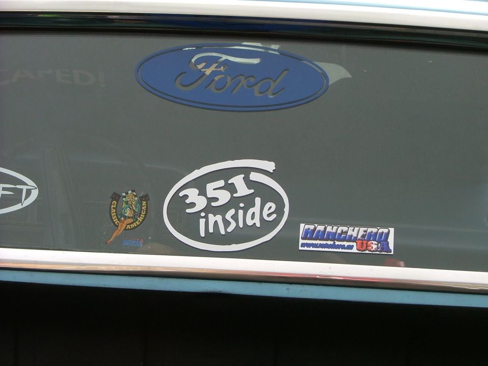 Ford oval badge and '351 inside' sticker on a vehicle's rear window, with a Ranchero sticker visible