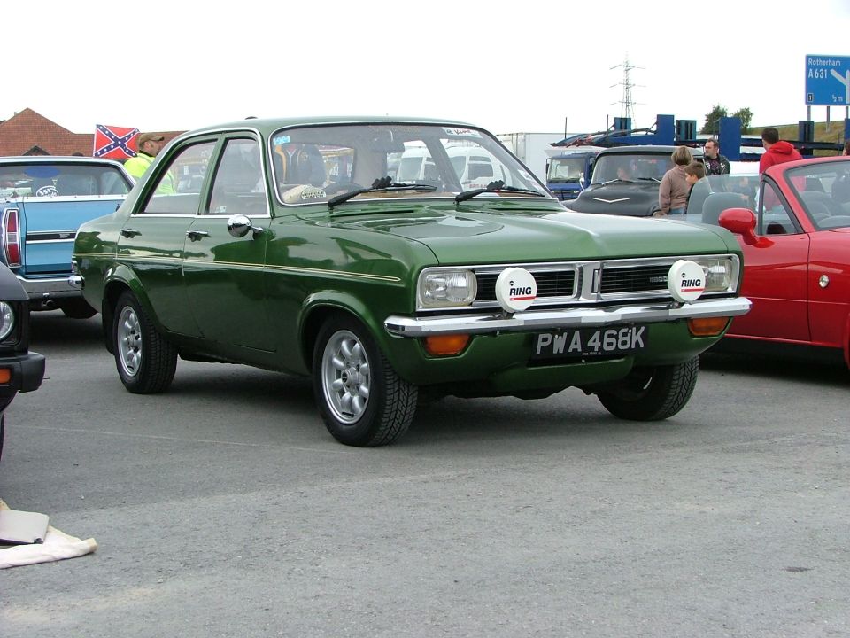 Green sedan with auxiliary lights and aftermarket wheels, front view