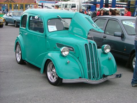 2001 Ford Fiesta - A teal vintage sedan with its hood open is displayed, showing off its classic grille and headlights.