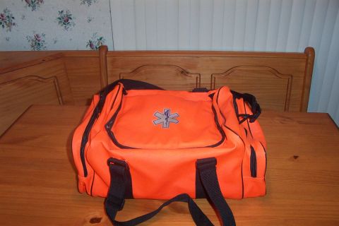 1998 Ford Crown Victoria - An orange medical bag with a star of life emblem sits on a wooden table.