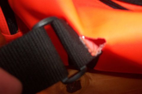 1998 Ford Crown Victoria - Detail of orange material and a black strap, showing a torn seam.
