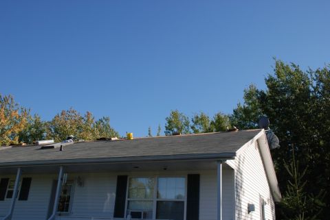 1996 Ford Bronco - A house roof is visible with a satellite dish and surrounding trees under a clear blue sky.