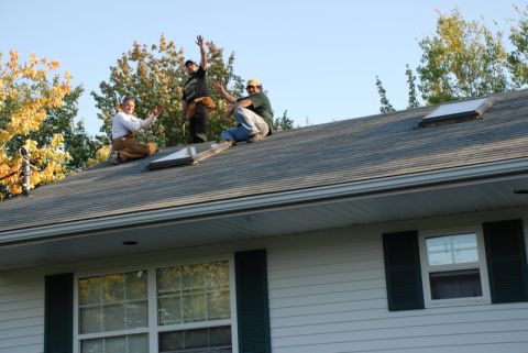 1996 Ford Bronco - Three roofers are working on a house roof under a clear blue sky, with trees in the background.