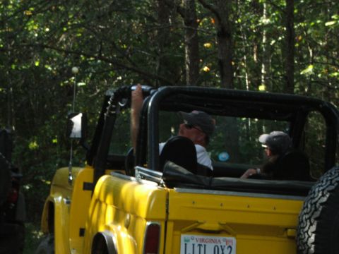 1996 Ford Bronco - A yellow Jeep CJ with two occupants is seen from the rear, with a Virginia license plate.