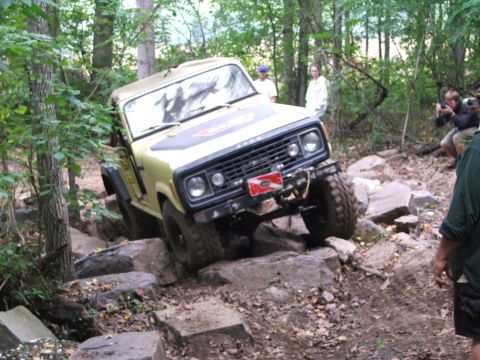 1996 Ford Bronco - An off-road vehicle navigates a challenging rocky terrain, with spectators observing the action.