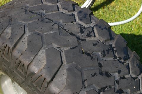 1986 Ford Bronco - A close-up view of a tire's tread pattern, showing its hexagonal blocks and wet surface.