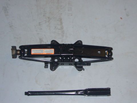 2000 Ford Crown Victoria - Scissor jack and lug wrench, likely for a car, shown on a flat surface.