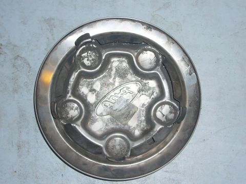 2000 Ford Crown Victoria - This is a close-up of a single Ford hubcap, showing its metallic finish and the embossed Ford logo.