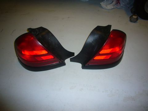 2000 Ford Crown Victoria - Pair of red car tail lights with black trim, shown on a floor.