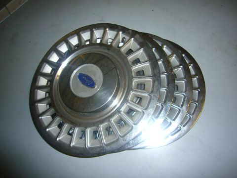 2000 Ford Crown Victoria - A set of four Ford hubcaps are shown, each with a blue oval Ford logo in the center.