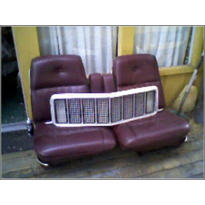 1973 Ford Ranchero - A white grille rests on top of two maroon car seats, possibly for a restoration project.