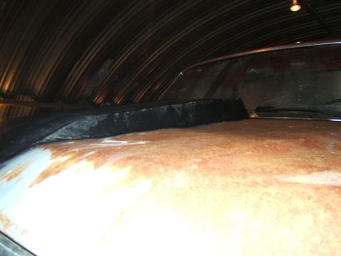 1980 Ford F-250 - Vehicle hood shows significant rust damage, parked indoors under a corrugated metal ceiling.