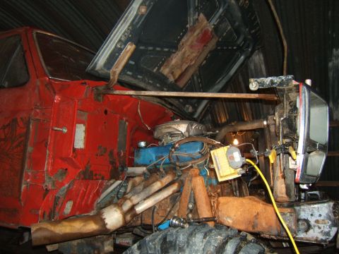 1980 Ford F-250 - Engine bay of a red truck, with the hood propped open, revealing the motor and surrounding components.