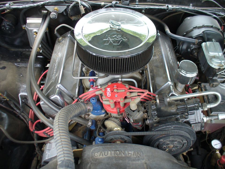 Engine bay with chrome valve covers, K&N air filter, and MSD ignition. A "CAUTION FAN" label is visible