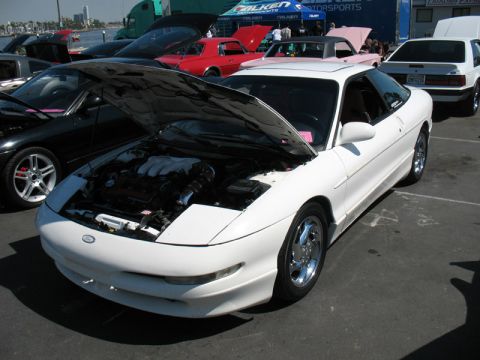 1995 Ford Probe - A white 1995 Ford Probe is displayed with its hood open, revealing the engine compartment.