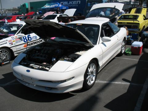 1995 Ford Probe - White 1995 Ford Probe on display with its hood open, parked next to other vehicles.