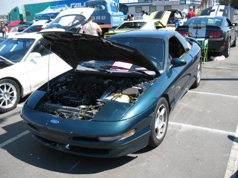 1995 Ford Probe - A 1995 Ford Probe is displayed with its hood open at an outdoor car event, alongside other cars.