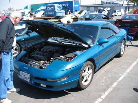 1995 Ford Probe - A blue 1995 Ford Probe is displayed with its hood open, alongside other vehicles at an outdoor gathering.