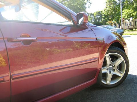 1990 Ford Bronco - Side view of a red car, focusing on the door and wheel.