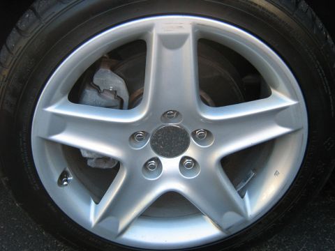 1990 Ford Bronco - Silver 5-spoke alloy wheel with tire and brake caliper.