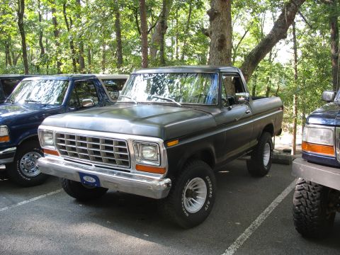 1995 Ford C-350 (Centurion Conversions) - This dark pickup truck features a prominent chrome grille and white-rimmed wheels, with a Ford badge on the front bumper.