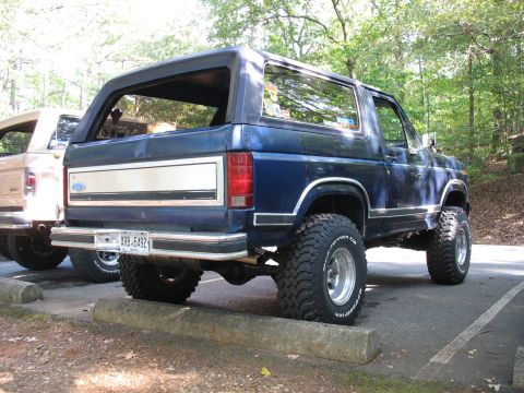 1995 Ford C-350 (Centurion Conversions) - Rear view of a blue Ford Bronco with a chrome trim panel and a license plate reading ARB-5492.
