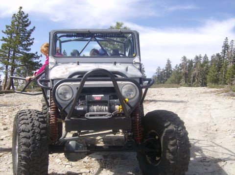1986 Ford Bronco - This heavily modified off-road vehicle is seen from the front on a dusty trail.