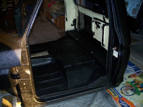 1979 Ford F-150 - Interior of a 1979 Ford F-150 shows black spray-on liner on the floor and door jambs, with gold paint visible on the door frame.