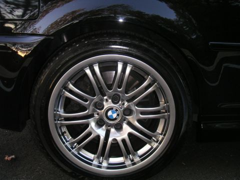 2002 BMW M3 - Close-up of a BMW wheel and fender, showing the distinctive alloy design and BMW badge.