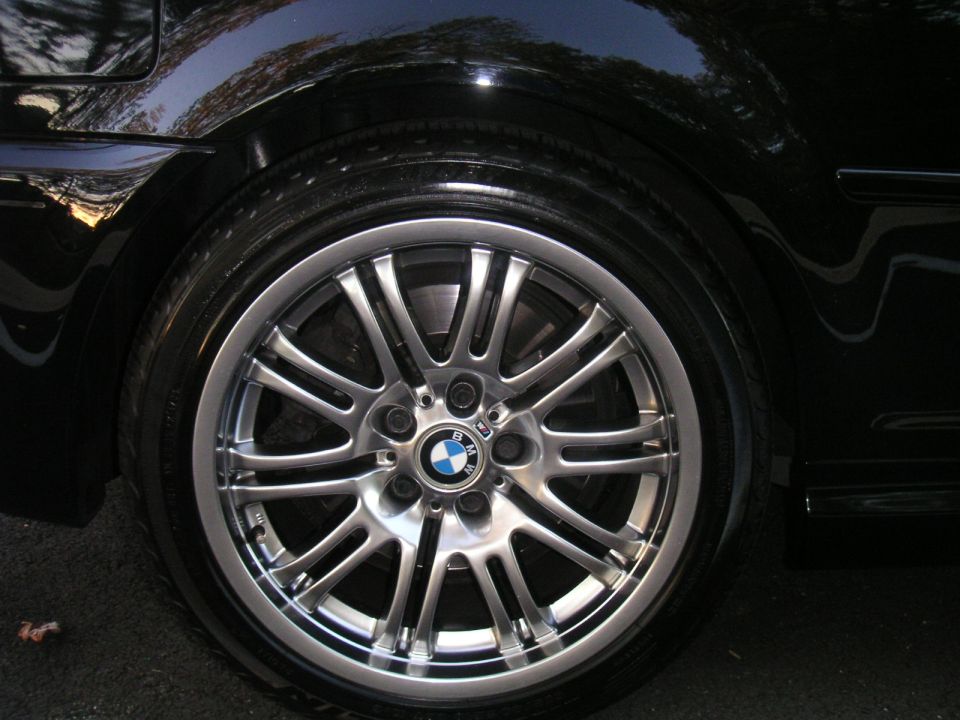 Close-up of a BMW wheel with a blue and white badge on the hub