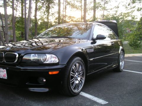 2002 BMW M3 - A black 2002 BMW M3 coupe is parked in a lot with its trunk open, viewed from the front three-quarter angle.