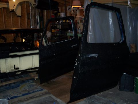1979 Ford F-150 - Two vehicle doors are in a workshop, likely undergoing restoration or repair.