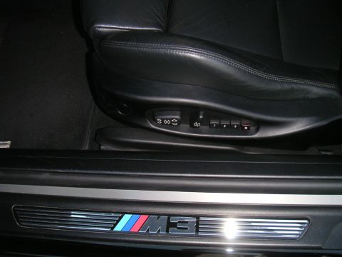 2002 BMW M3 - The M3 badge is visible on the door sill, along with seat memory buttons and part of the driver's seat.