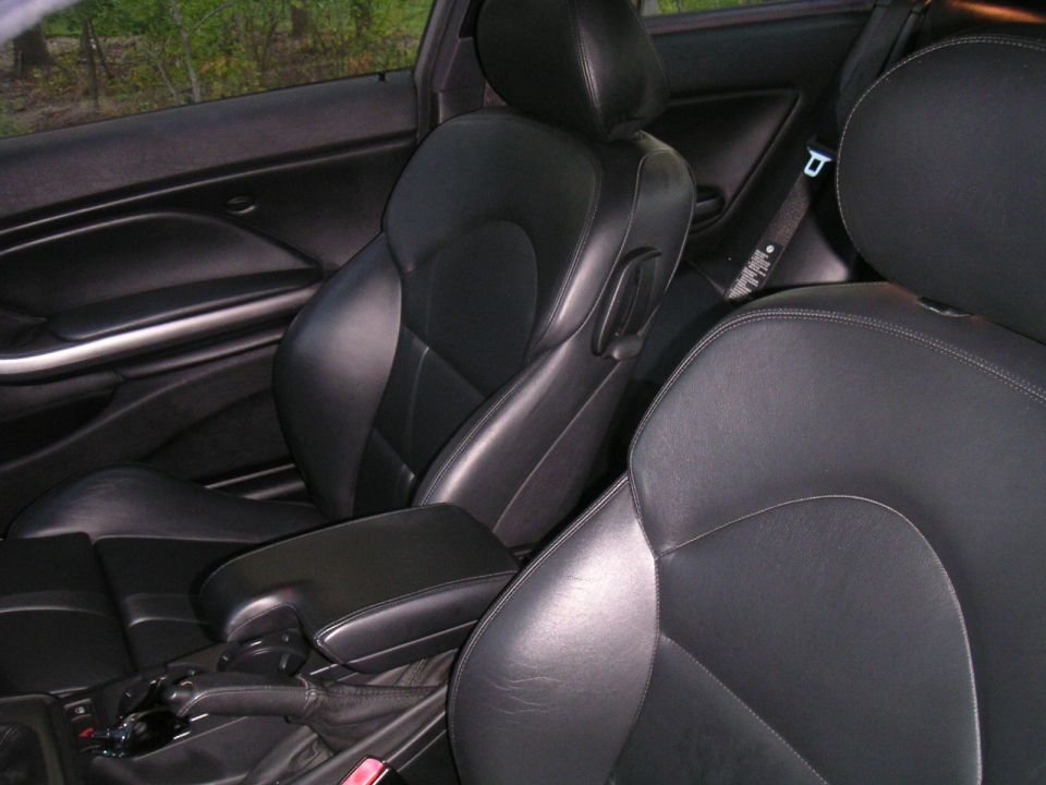 Black leather car seats and center console with a Supermotors.net watermark